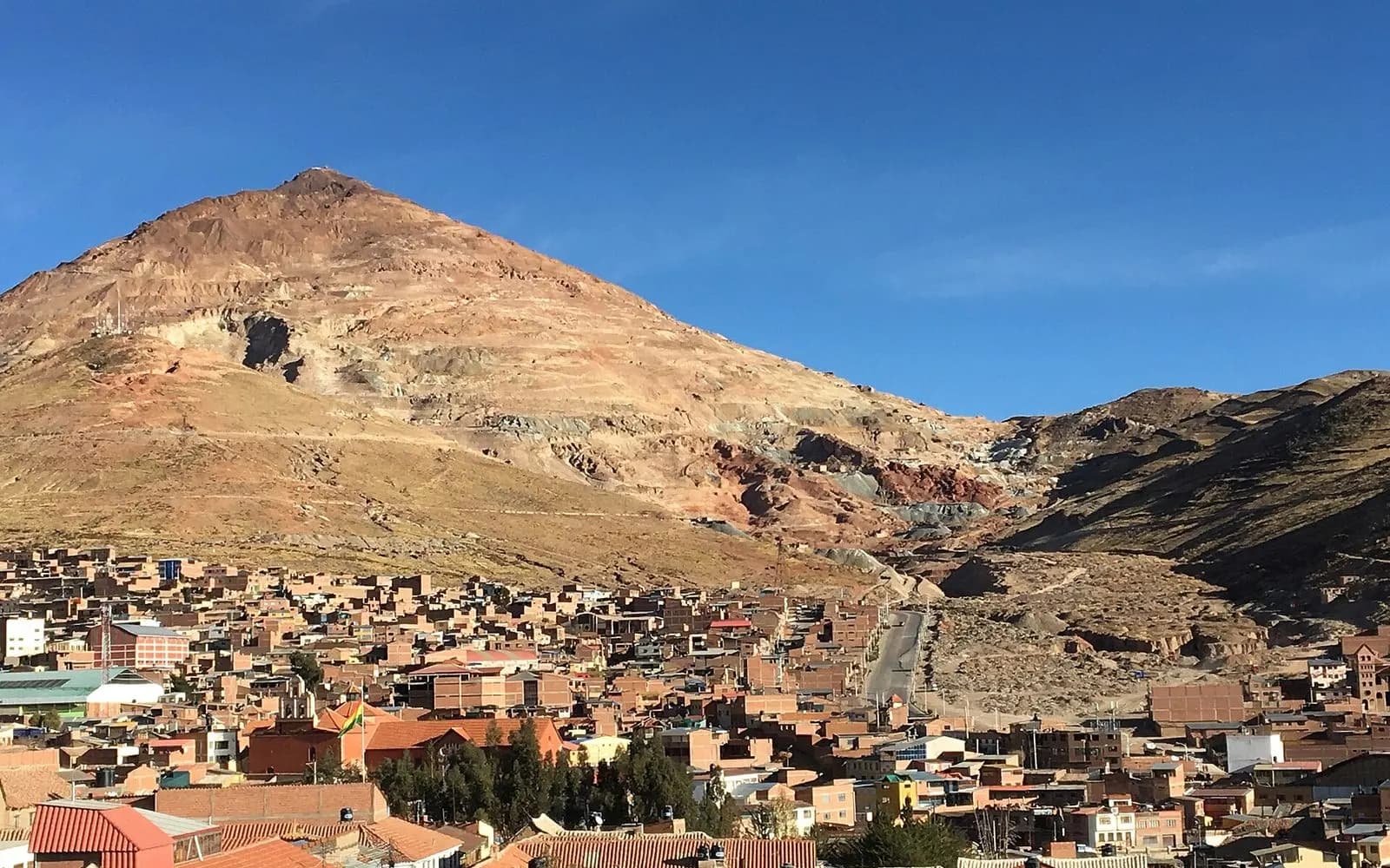 Cerro Rico mountain above the red tile roofs of Potosí under deep blue sky, Bolivia