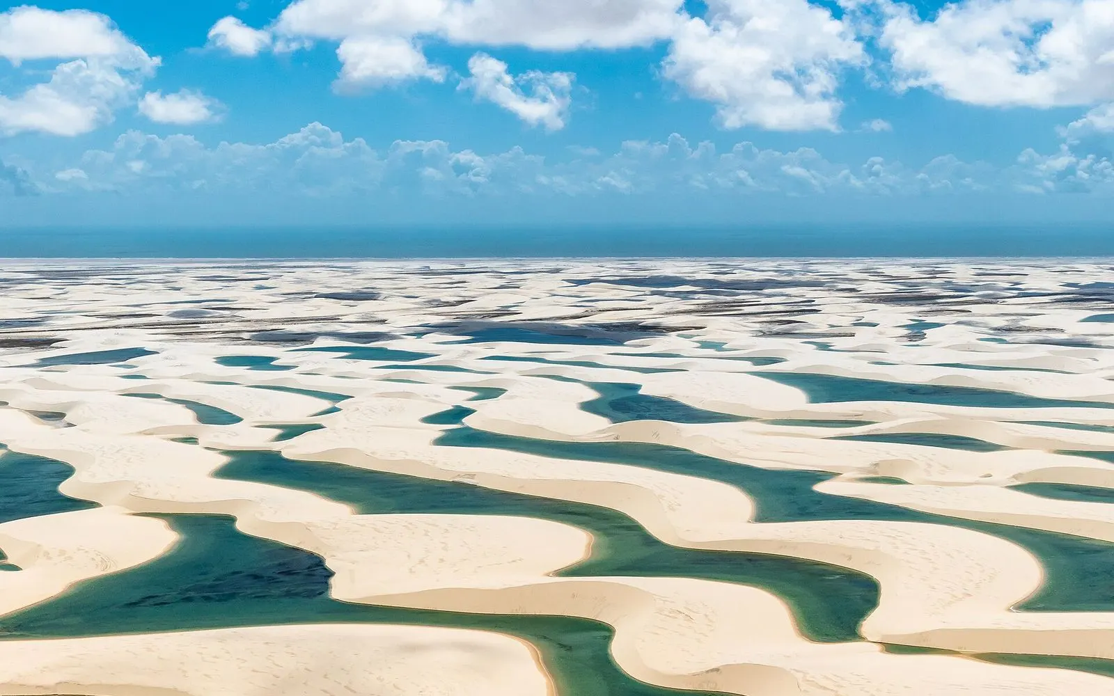 Aerial view of white sand dunes dotted with blue-green rainwater lagoons, Lençóis Maranhenses, Maranhão, Brazil