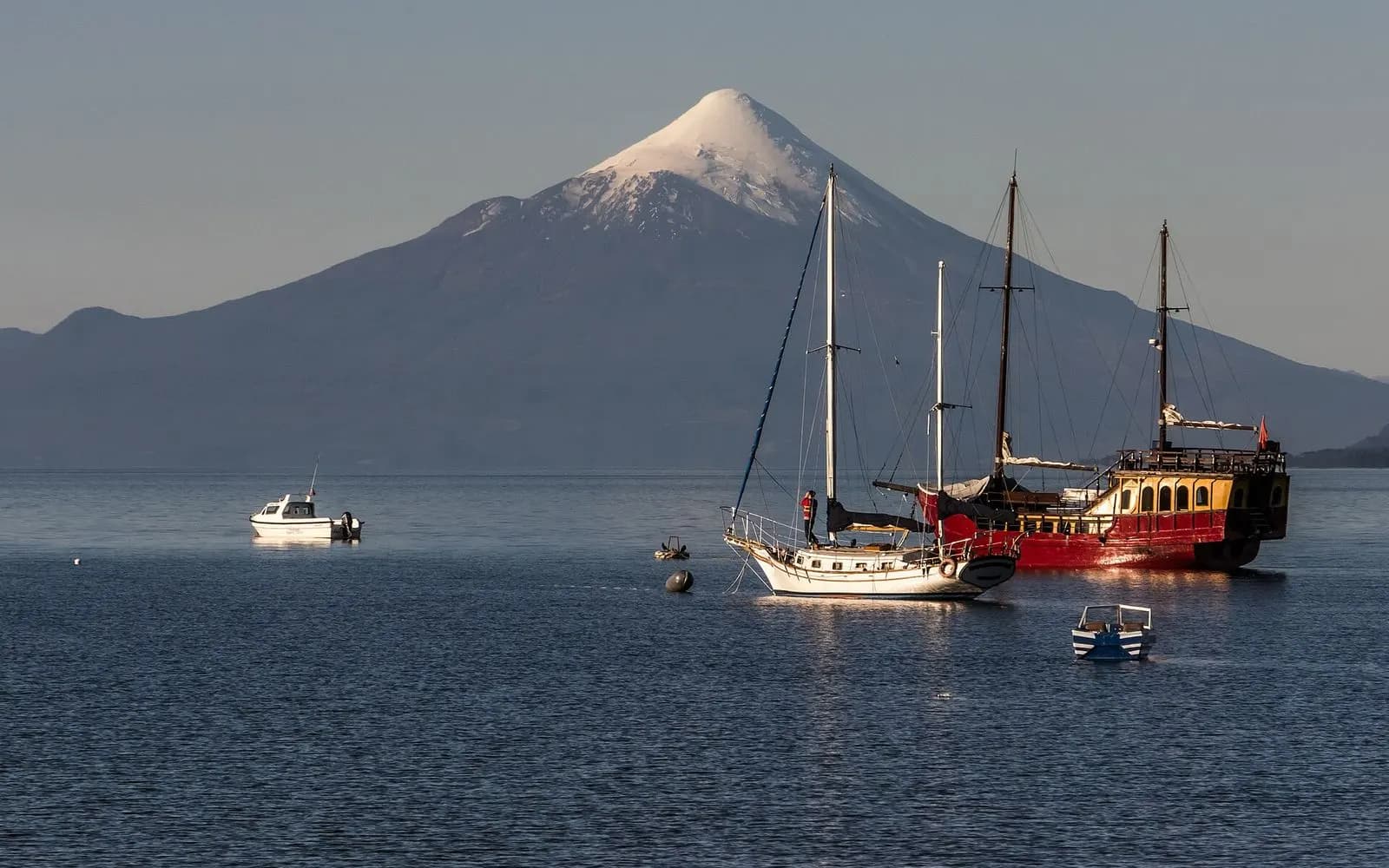 Snow-capped Osorno volcano above sailing boats moored on Lake Llanquihue at Puerto Varas, Chile