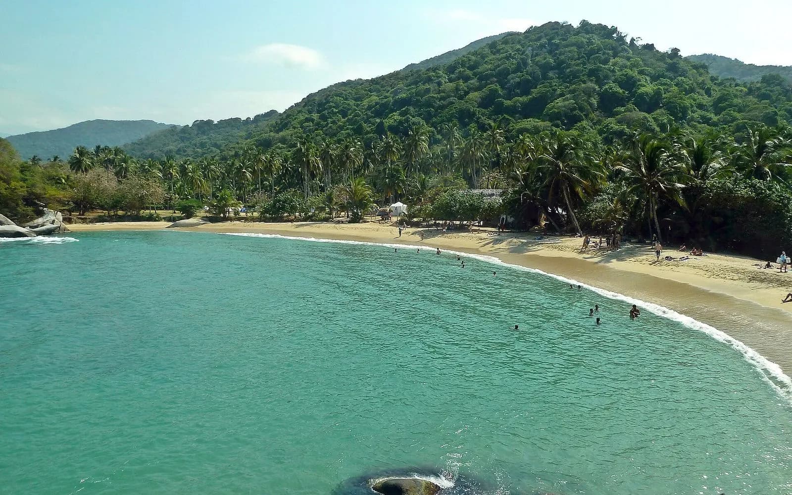 Turquoise bay fringed with palms and forested hills at Cabo San Juan, Tayrona, Colombia