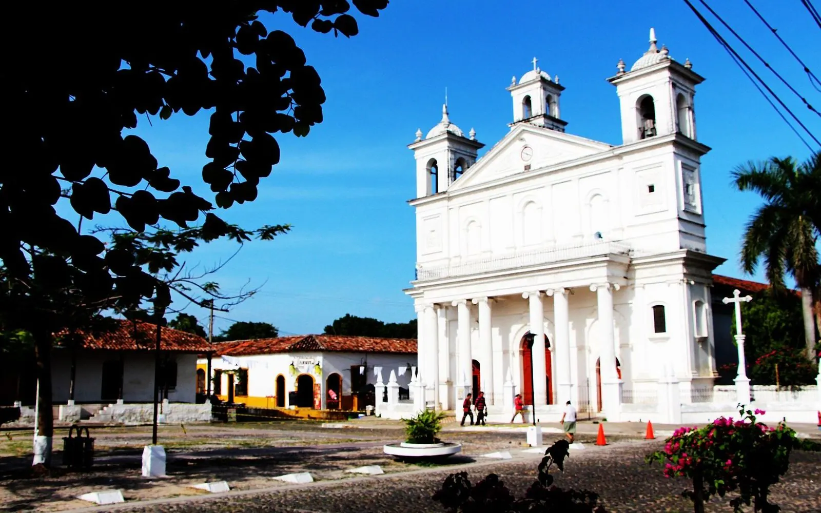 White Santa Lucía church under a blue sky on the plaza of Suchitoto, El Salvador