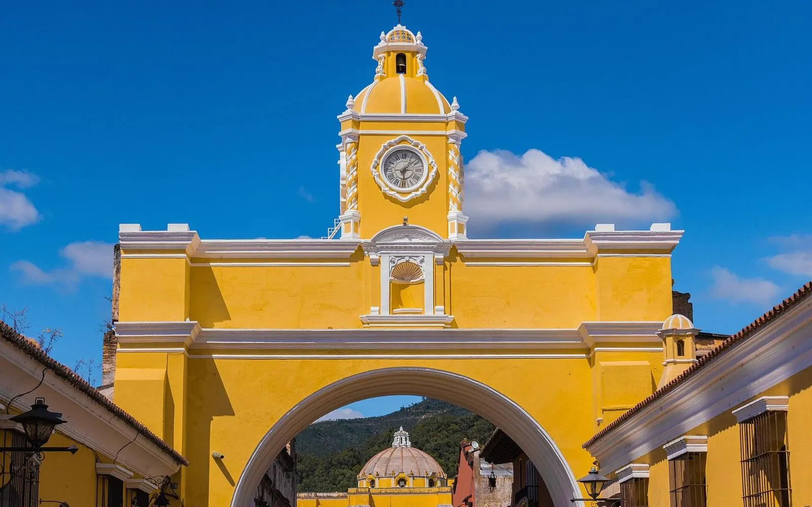 The yellow Santa Catalina Arch against a deep blue sky in Antigua Guatemala, Guatemala