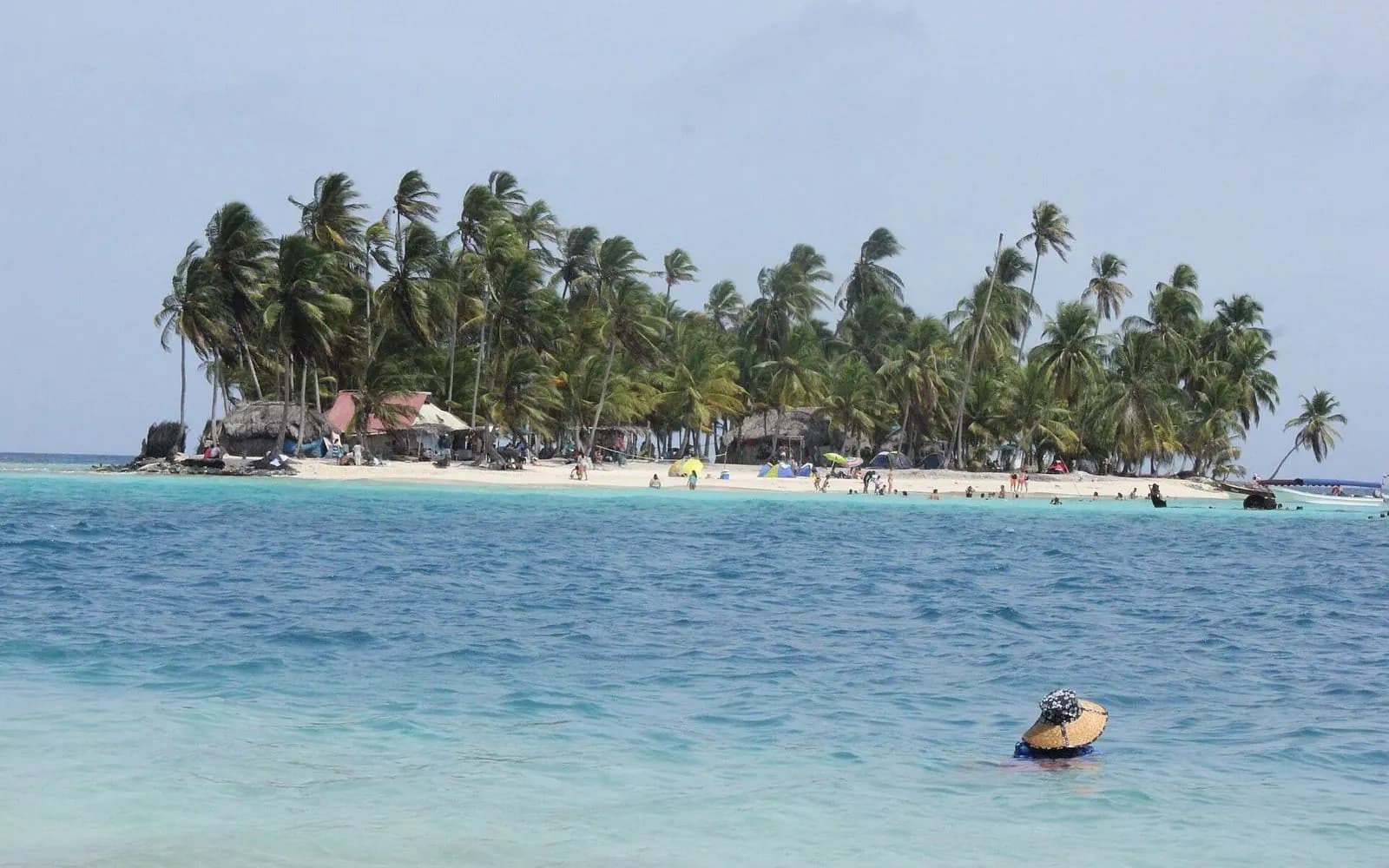 Small palm-covered island ringed by turquoise water in the Guna Yala archipelago, San Blas, Panama