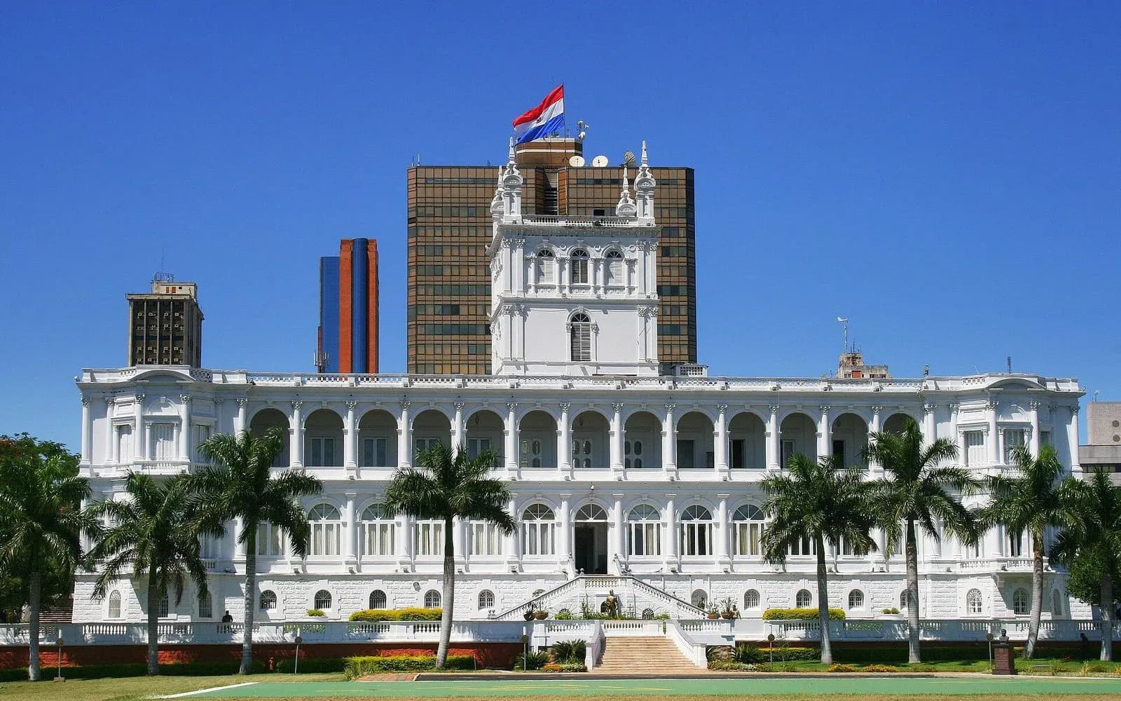 The white Palacio de los López with its central tower and palm trees, Asunción, Paraguay