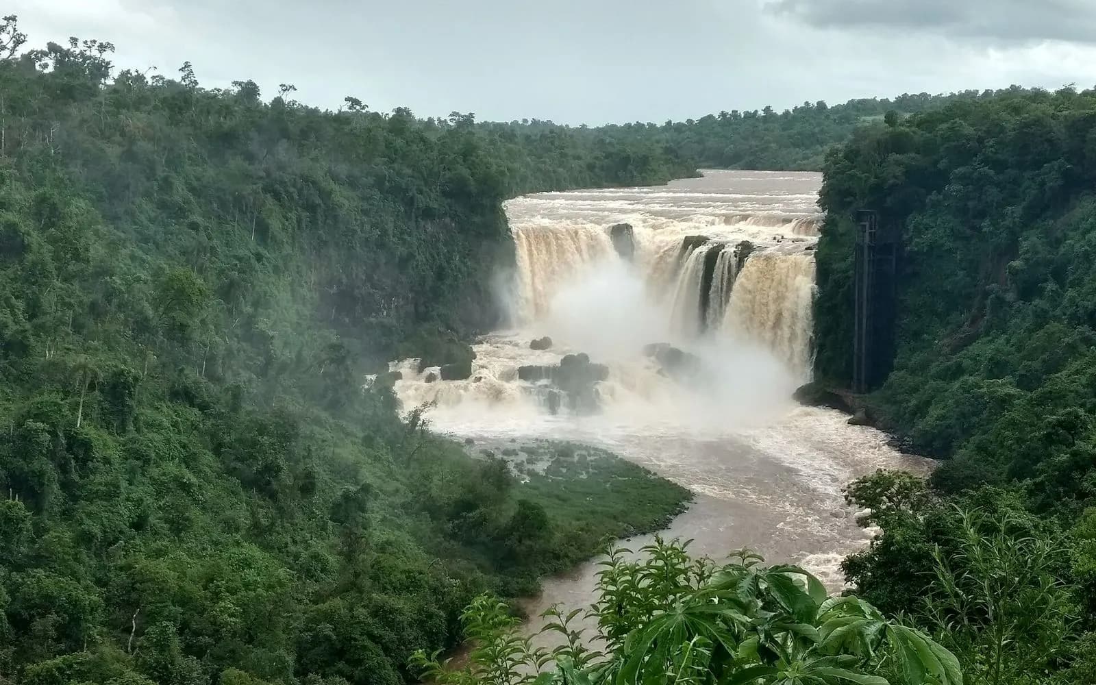 Muddy-brown Monday Falls plunging through a lush green gorge, Presidente Franco near Ciudad del Este, Paraguay