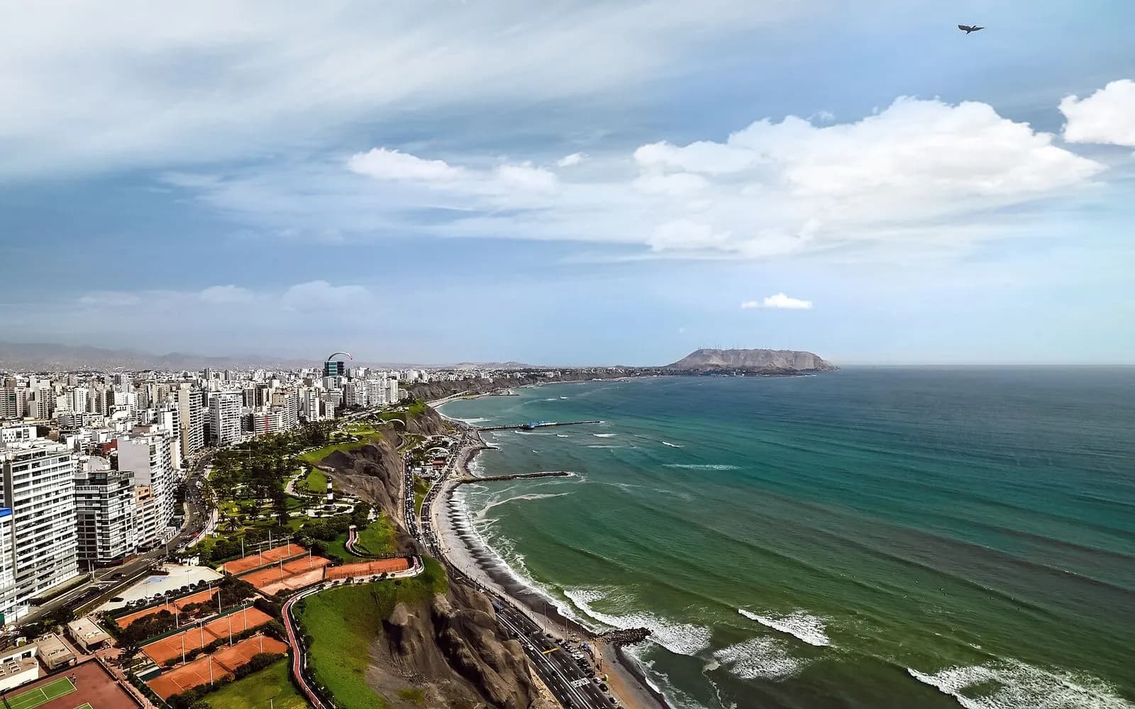 Miraflores towers and green cliff parks above the Pacific surf of the Costa Verde, Lima, Peru