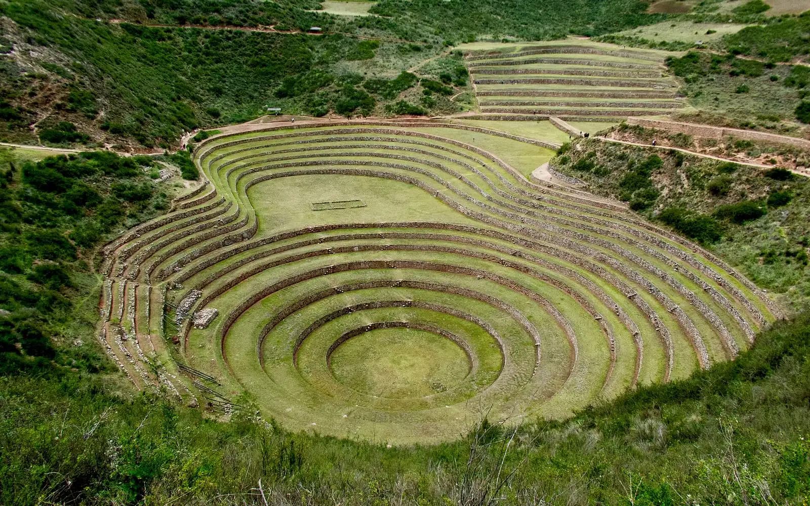 Concentric circular Inca agricultural terraces of Moray set in green hills, Sacred Valley, Peru