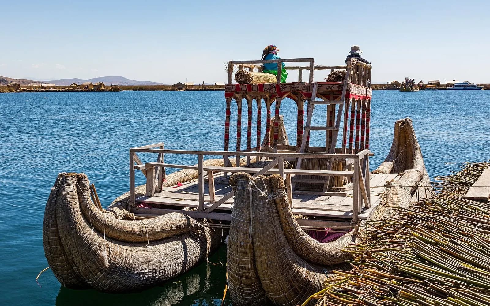 Reed boats moored at a floating Uros reed island on blue Lake Titicaca, Peru
