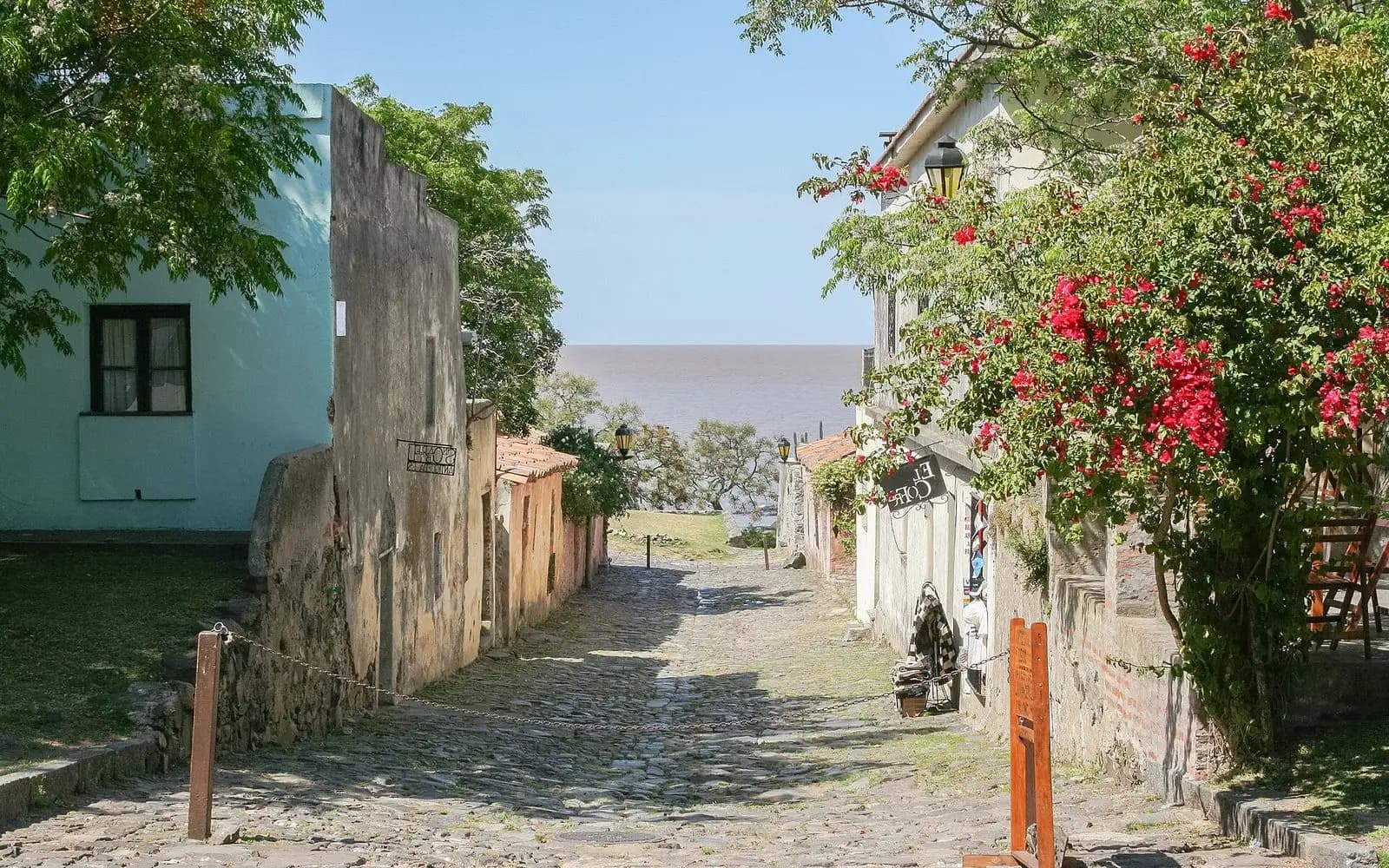 A cobbled colonial lane lined with flowering bougainvillea leading to the river, Colonia del Sacramento, Uruguay