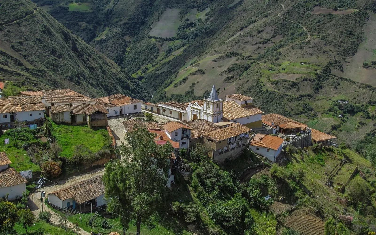 Colonial mountain village with a white church above terraced green slopes, Los Nevados, Mérida, Venezuela